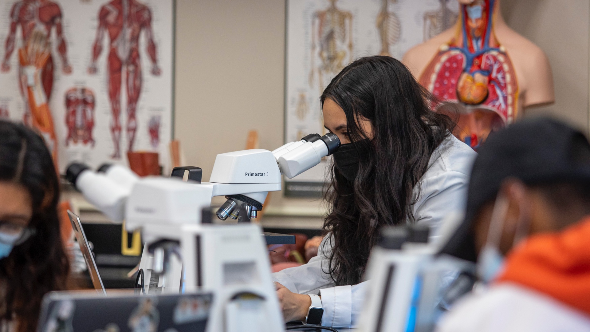 student looking into microscope